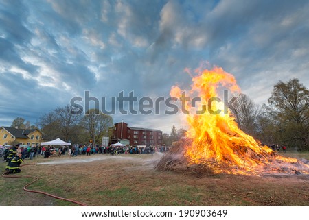 NORRTALJE - APR, 30, 2014: The traditional Valborg fire at Haverodal with firemen controlling the fire in April 30, 2014, Norrtalje, Sweden. Tradition in the Nordic countries to welcome the spring.