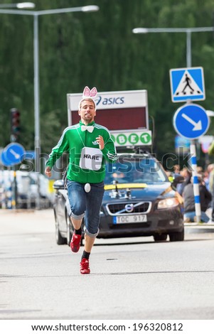 STOCKHOLM - MAY 31: Spectator with rabbit costume running before the leader at a short distance at ASICS Stockholm Marathon 2014. May 31, 2014 in Stockholm, Sweden.