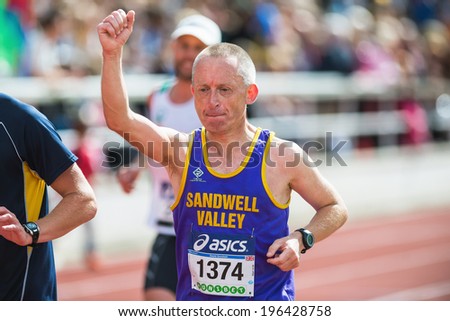 STOCKHOLM - MAY 31: Man rising his hand on the final stretch at Stockholm Stadion in ASICS Stockholm Marathon 2014. May 31, 2014 in Stockholm, Sweden.