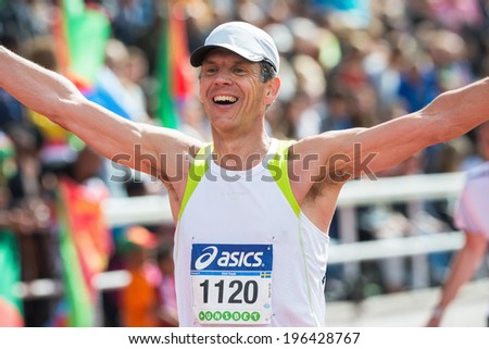STOCKHOLM - MAY 31: Man rising his hands on the final stretch at Stockholm Stadion in ASICS Stockholm Marathon 2014. May 31, 2014 in Stockholm, Sweden.