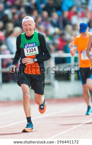 STOCKHOLM - MAY 31: Older man running the final stretch at Stockholm Stadion in ASICS Stockholm Marathon 2014. May 31, 2014 in Stockholm, Sweden.