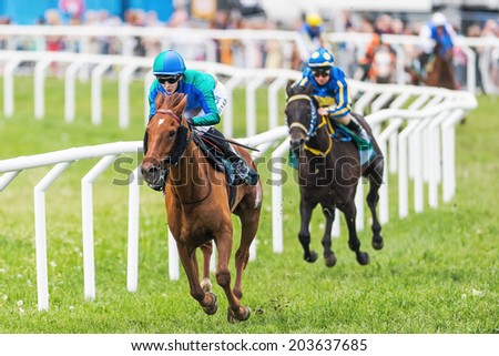 STOCKHOLM - JUNE 6: Two jockeys out of the fourth curve at the Nationaldags Galoppen in Gardet. June 6, 2014 in Stockholm, Sweden.