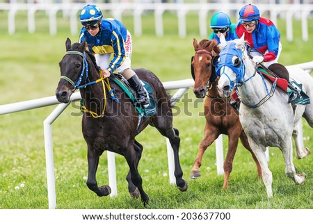 STOCKHOLM - JUNE 6: Three jockeys out of the fourth curve at the Nationaldags Galoppen in Gardet. June 6, 2014 in Stockholm, Sweden.