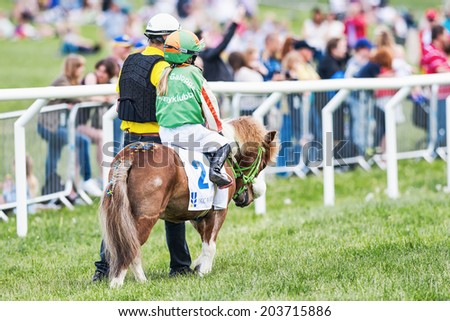 STOCKHOLM - JUNE 6: Pony racer warming up with her trainer before the start of childrens race at Nationaldags Galoppen. June 6, 2014 in Stockholm, Sweden.