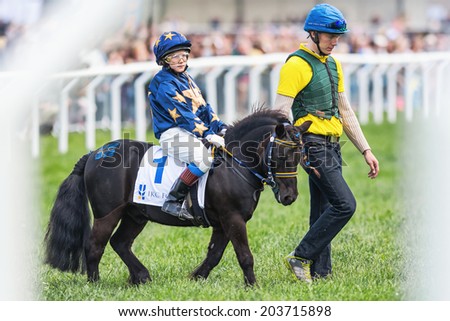 STOCKHOLM - JUNE 6: Pony racer warming up with her trainer and horse before the start of childrens race at Nationaldags Galoppen. June 6, 2014 in Stockholm, Sweden.