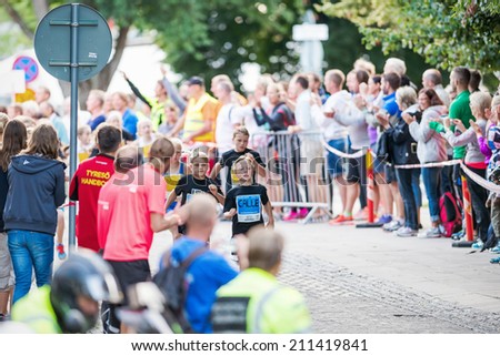 STOCKHOLM - AUG, 16: The leader after the first curve of the youngest in the Midnight Run for children (Lilla Midnattsloppet) event cheered on. Aug 16, 2014 in Stockholm, Sweden