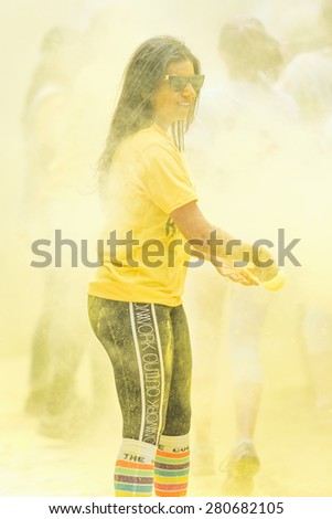 STOCKHOLM, SWEDEN - MAY 23: Volunteer girl spraying yellow paint at Stockholm Color Run in Tantolunden or Tanto on May 23, 2015. People from all walks of life participated in the run.