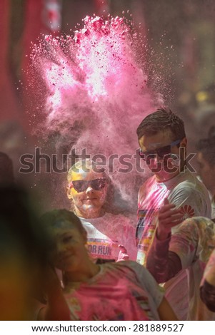 STOCKHOLM, SWEDEN - MAY 23: Cloud of pink color over two happy persons at Stockholm Color Run on May 23, 2015. People from all walks of life participated in the run.