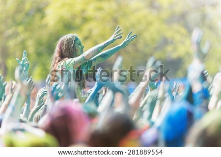 STOCKHOLM, SWEDEN - MAY 23: Girl sitting on friends shoulders with crowds arms waving around her at Stockholm Color Run in Tantolunden or Tanto on May 23, 2015.