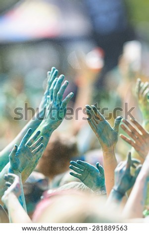 STOCKHOLM, SWEDEN - MAY 23: Happy people rising their hands in green at Stockholm Color Run on May 23, 2015. People from all walks of life participated in the run.