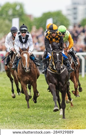 STOCKHOLM - JUNE 6: Jockeys and horses running towards the camera at the Nationaldags Galoppen at Gardet. June 6, 2015 in Stockholm, Sweden.
