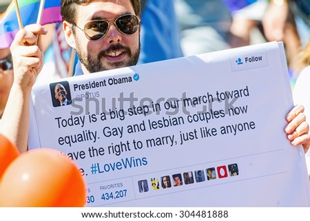 STOCKHOLM, SWEDEN - AUGUST 1, 2015: Man with president Barack Obamas tweet regarding equal rights at the Pride parade in Stockholm.