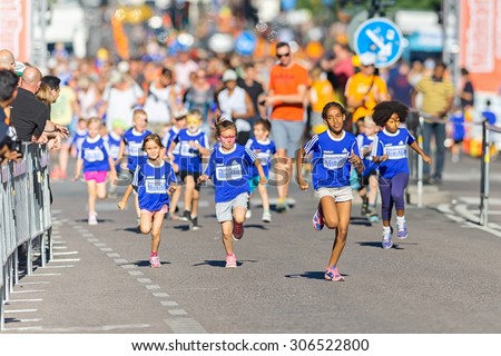 STOCKHOLM, SWEDEN - AUGUST 15, 2015: Fast group of kids at the Minimil for the youngest runners at Midnattsloppet. The track is 300 meters and the runners are aged 2-8 years.