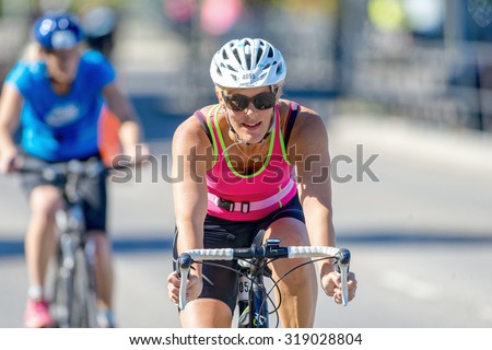 STOCKHOLM - AUG 23, 2015: Amateur triathlete cyclist in front view with happy face at the ITU World Triathlon event in Stockholm.