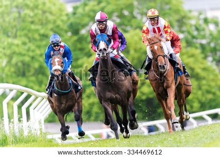 STOCKHOLM, SWEDEN - JUN 6, 2015: Horses with jockeys out of a curve in fast pace at Nationaldagsgaloppen at Gardet.