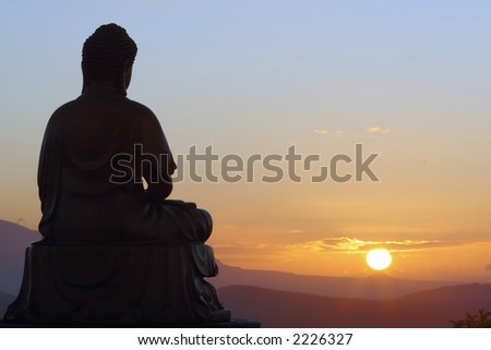 Buddha silhouette looking into the sunrise over the mountains