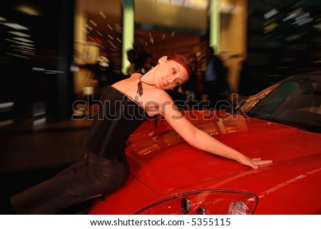 Pretty young woman and a red sports car.