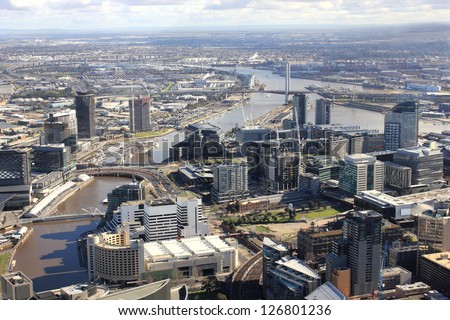 Aerial melbourne city view with tall buildings and river running through middle