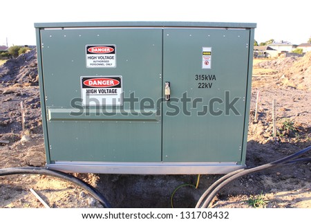 Suburban transformer substation metal box with warning signs