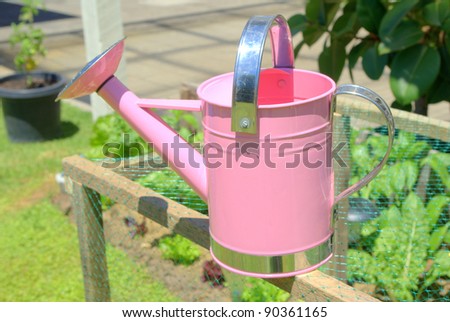 Childs pink watering can at home in the garden