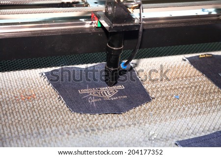 BANGKOK - JUNE 28 :Laser sketching a logo on fabric at Garment  Manufacturers Sourcing 2014 on June 28,2014 in BITEC ,Bangkok,  Thailand.