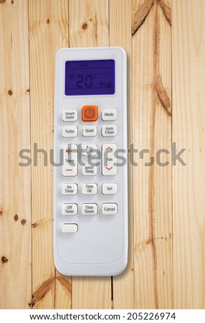 Air conditioner remote control on wood background