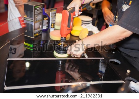 BANGKOK - AUGUST 16 :Unidentified people show polishing on car mirror at  Big Motor Sale 2014 on June 16,2014 in BITEC ,Bangkok, Thailand.