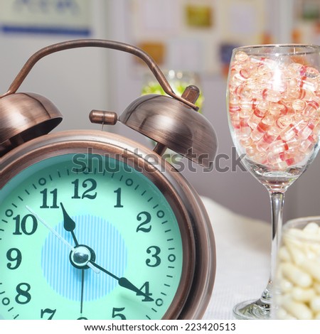 Alarm clock and drug capsule ,Pills and clock on table,closeup