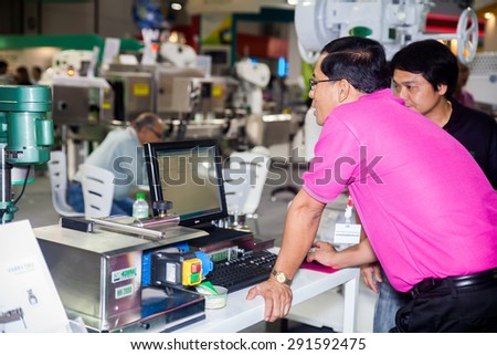 BANGKOK ,THAILAND - JUNE 20: Unidentified people set up machine \
with computer in PROPAK ASIA 2015, on JUNE 20, 2015 in Bangkok, \
Thailand.