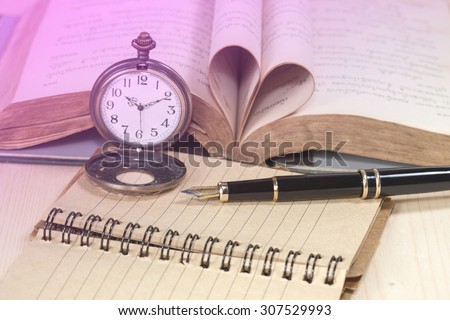old books, pocket clock, paper and fountain pen on wooden ,\
shallow DOF
