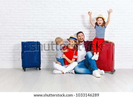concept travel and tourism. happy family with suitcases near empty wall