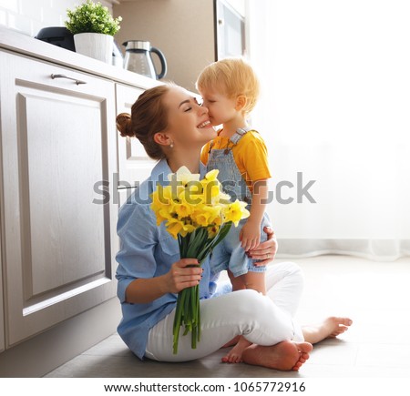 happy mother\'s day! baby son congratulates mother on holiday and gives flowers