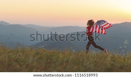 young happy woman with flag of united states enjoying the sunset on nature