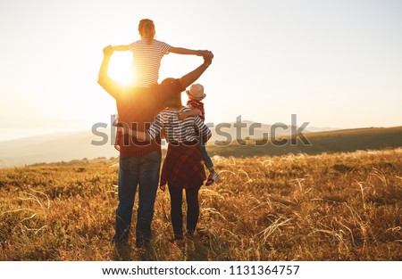 Happy family: mother, father, children son and  daughter on nature  on sunset