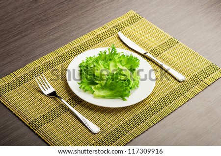 diet concept. green leaf lettuce on a plate with a fork and knife
