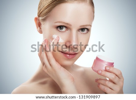 skin care. face of a happy beauty healthy girl with jar of cream