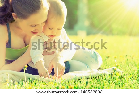 Happy Family. Mom And Baby Resting In A Meadow In The Summer Outdoors In The Park