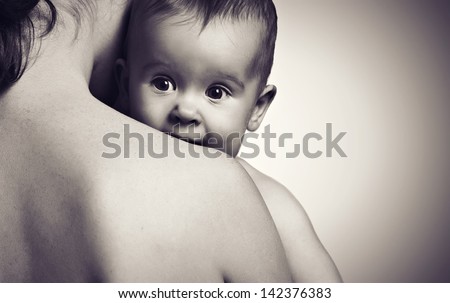 cute baby looking at hands of the mother in an embrace, monochrome