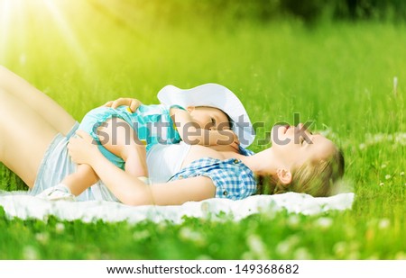 happy family. Mother and baby are resting, relax sleep outdoors on the grass in the summer park