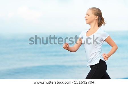 Morning Jog. Young Woman Running On The Beach On The Coast Of The Sea