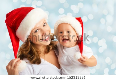 happy family mother and baby in red Christmas hats happy family mother and baby in red Christmas hats
