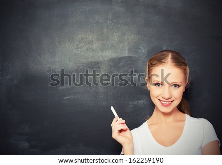 woman with chalk on an empty blackboard woman with chalk on an empty blackboard