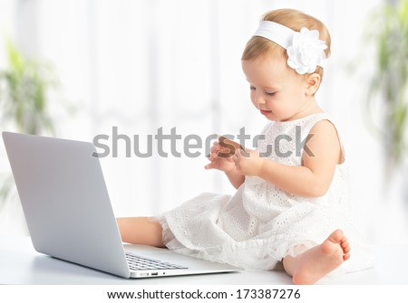baby girl with laptop and credit card shopping on the Internet