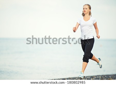 morning jog. young woman running on the beach on the coast of the Sea
