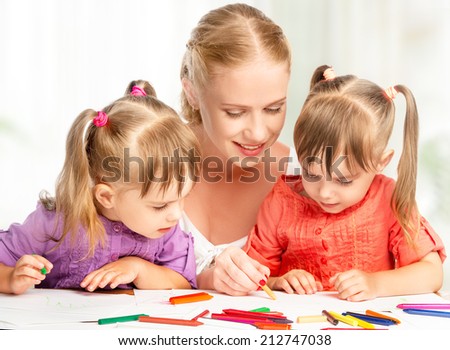 children little twin sisters draw paints with her mother in kindergarten children little twin sisters draw paints with her mother in kindergarten