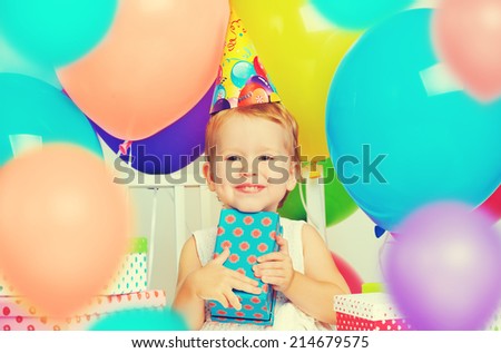 Children\'s birthday. happy little girl with gifts and balloons