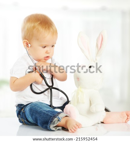 cute baby plays in doctor toy bunny rabbit and stethoscope