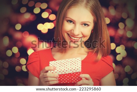 beauty pretty girl in red dress with gift box to Christmas or Valentine\'s Day