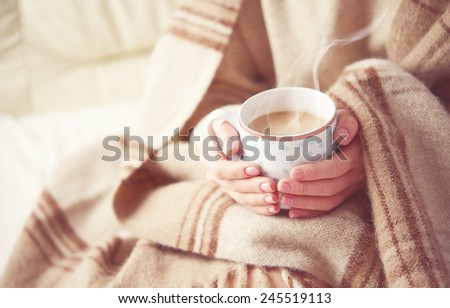 warm cup of hot coffee warming in the hands of a girl