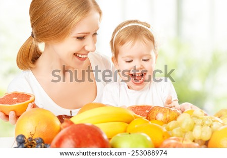 happy family mother and daughter little girl, eat healthy vegetarian food, lots of fruit